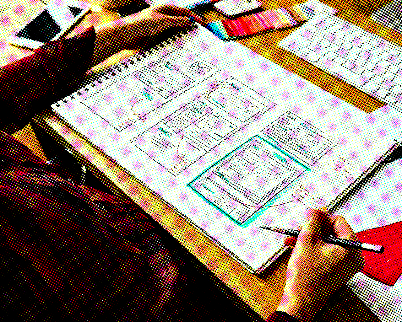 A web designer looking at some pieces of paper containing UX designs